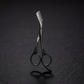 Pair of brow scissors with a comb on a dark textured background